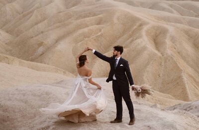 Groom spinning his bride with a canyon behind them at Zabriskie Point