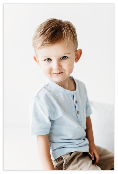 Family Photographer, Boy sitting in front of white backdrop