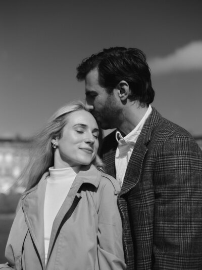 Black and white photo  of Fallon Stovall and her husband standing in the grass with the landscape in the background