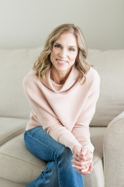 Stephanie sitting on a couch smiling