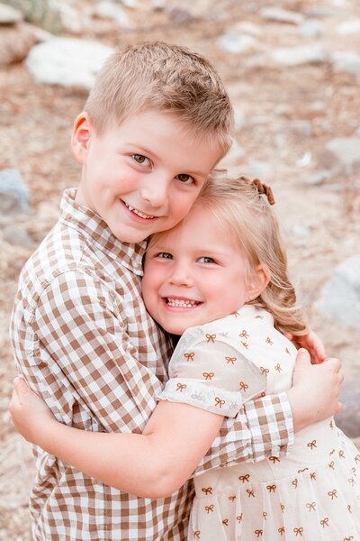 botherr and sister hugging smiling at the camera