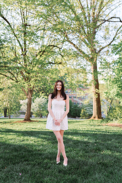 Girl in white dress stands at Ayres Hall in Knoxville, Tennessee