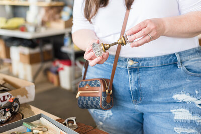 Lauren examines antique glass doorknob while wearing Gucci purse