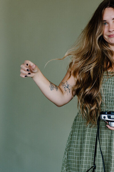 Minnesota wedding photographer twirls her hair while holding her camera