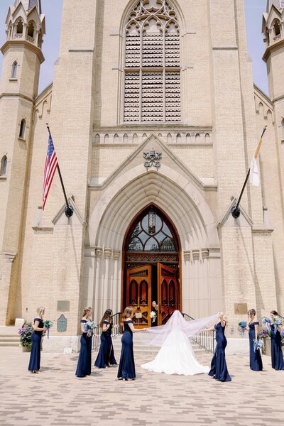 bride and bridesmaids standing outside of a Catholic church