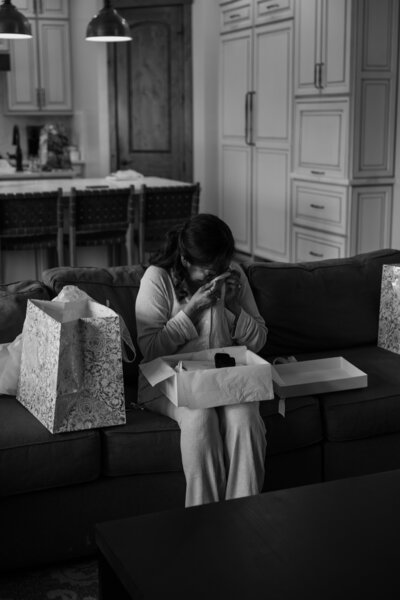 Mother of bride opening gift from her daughter, in black and white.