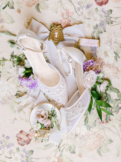 Flatlay of beautiful white heels and flowers