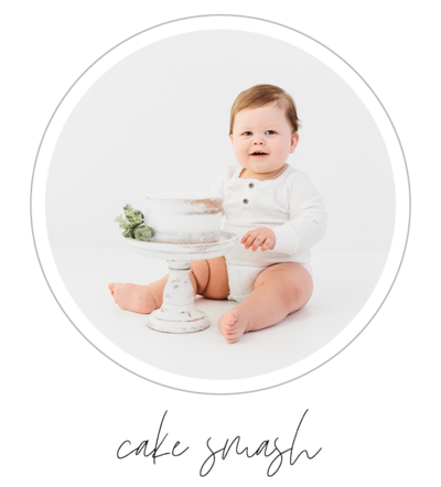 A one year old boy sits confidently in an all-white studio, his eyes shining with excitement. In his hands, he holds a pristine white cake, its smooth icing reflecting the light. As he takes his first bite, his eyes light up, and a smile spreads across his face. This precious moment is captured in a photograph by Bri Sullivan Photography, showcasing the joy and innocence of childhood.