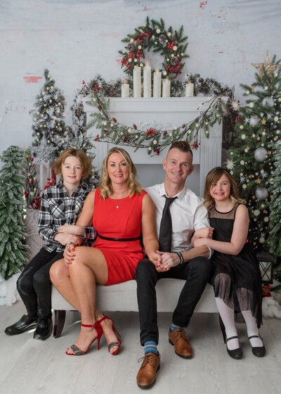 adorable brothers sitting on a couch in a christmas set