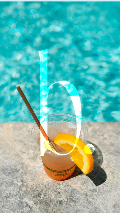 Bondi Marketing monogram logo faded out on top of a photo of a drink with an orange slice on it sitting by the pool