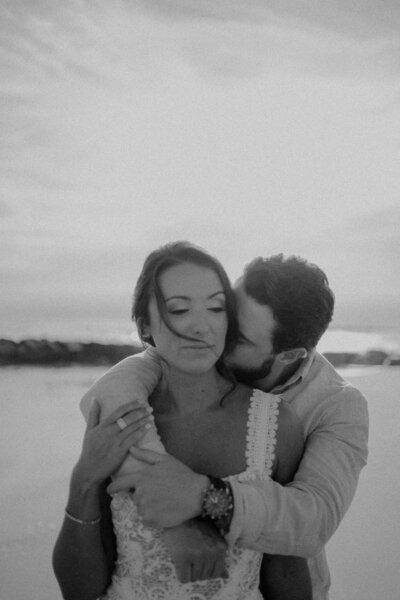 groom hugging bride from behind