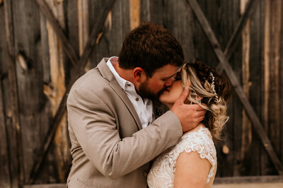 bride and groom at their outdoor Little Rock Arkansas venue kissing for their fall wedding