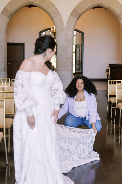 Wedding planner helps a bride into her dress at Outreach Event Space in downtown Kansas City