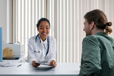 Man sitting at desk with doctor 