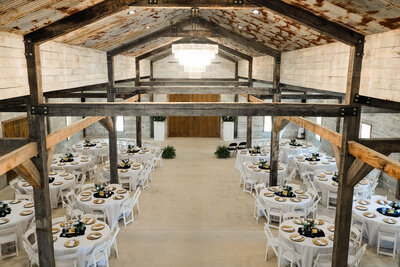 Indoor reception setup at The Grove with farmhouse tables, elegant lighting, and western-modern décor.