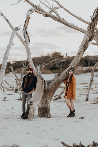 couple on beach with driftwood