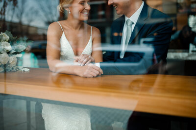 bride and groom sitting in coffee shop