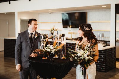 wedding couple posed with wedding cake near bar
