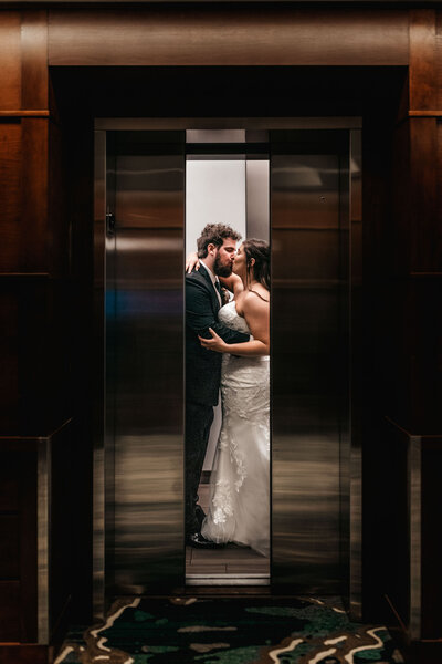 Bride and Groom kissing as elevator door closes at DoubleTree by Hilton wedding in Manchester NH by Lisa Smith Photography