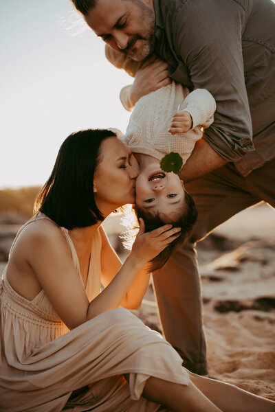 Parents cuddling children outdoors at sunset, taken by Sydney family photographer Sophie Lea.