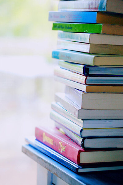 A neatly arranged stack of books, showcasing various colors and sizes, symbolizing knowledge and learning.