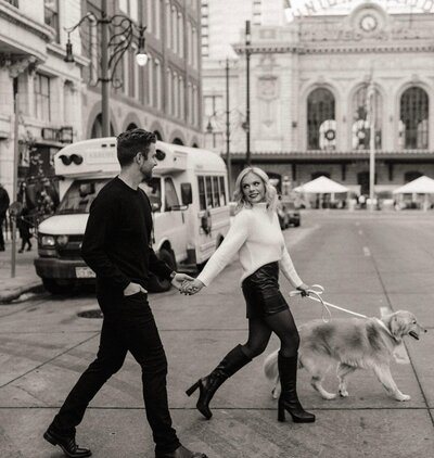couple-walking-across-city-street-with-dog