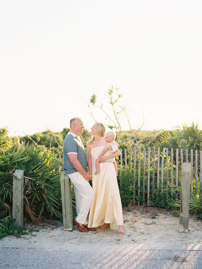 Hazy film photo of couple holding hands while woman holds baby on her hip