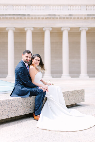 Bride and groom sitting outside Legion of Honor Museum wedding venue in San Francisco, photo by Anastasiya Photography - San Francisco Wedding Photographer