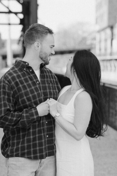 Cinematic wide shot of the couple embracing on the summit, with soft focus and natural light.
