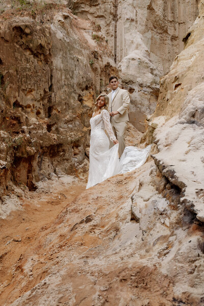 Epic moment of a couple in love, surrounded by red rock canyon views, captured by a travel elopement photographer. 