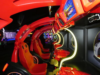 Group of friends enjoying arcade games, including basketball hoops and classic Pac-Man, in a vibrant, fun-filled game zone perfect for all ages.