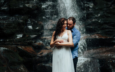 couple embracing under waterfall