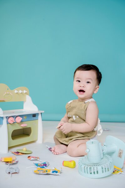 Baby sitting up playing in blue room