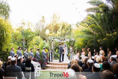 Bride and Groom stand at the altar saying their vows at the outdoor site at Eden Gardens in Moorpark, CA