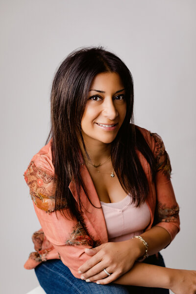 Woman in floral blazer smiles for headshot
