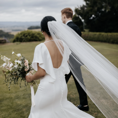 Bride and groom walking in a field