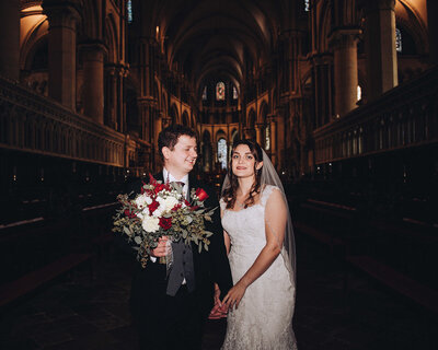 Bride and groom posing for portrait with white walls