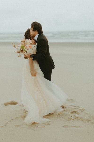 bride and groom hugging on the beach