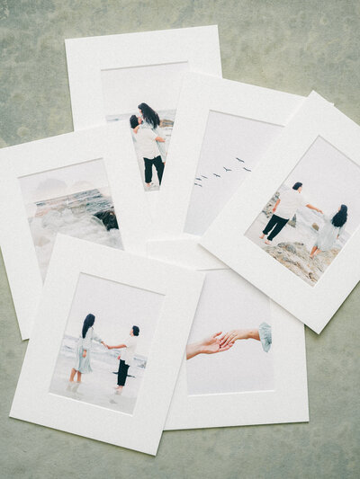 Ink prints laid out on a flat lay to showcase the different prints from sessions and weddings with white borders around the images.