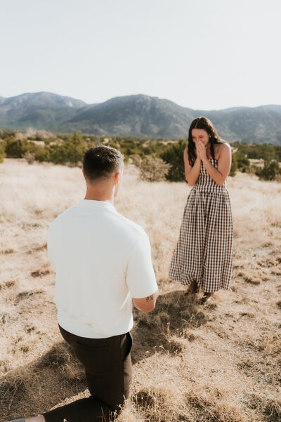 Bride jumping over a puddle of water during their engagement session in Old Town, Albuquerque.