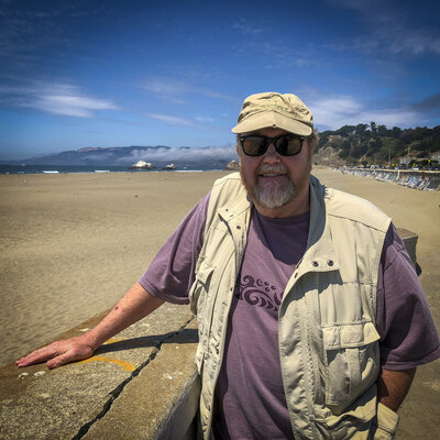 Photographer Fred W. Gillaspy pauses during photo shoot at Ocean Beach, San Francisco, CA.