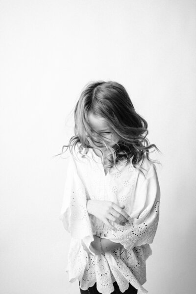 a beautiful black and white fine art photograph of a young girl shaking her head in a rio, wi personality portrait. 