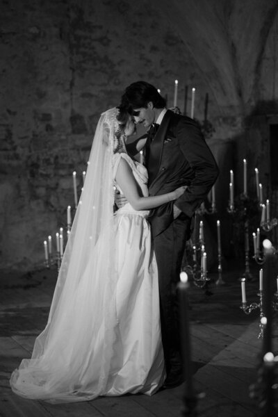 A couple on their wedding day surrounded by candelabras in a cave in Italy