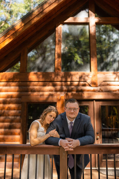 Bride and groom standing in front of log cabin during their Indiana wedding photography session