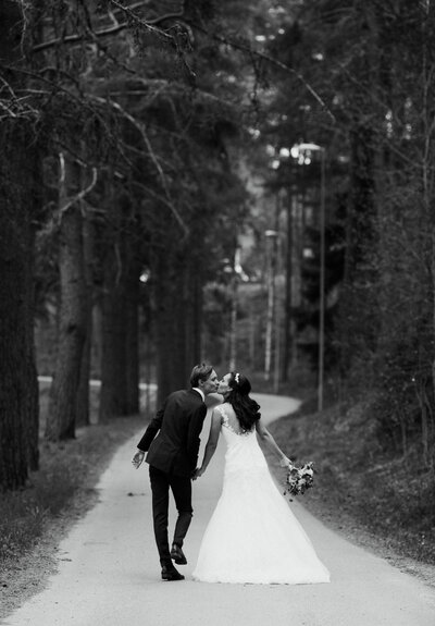 Bride and groom walking through forest