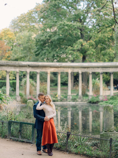 a couple standing in front of some old columns in parc moncea in paris