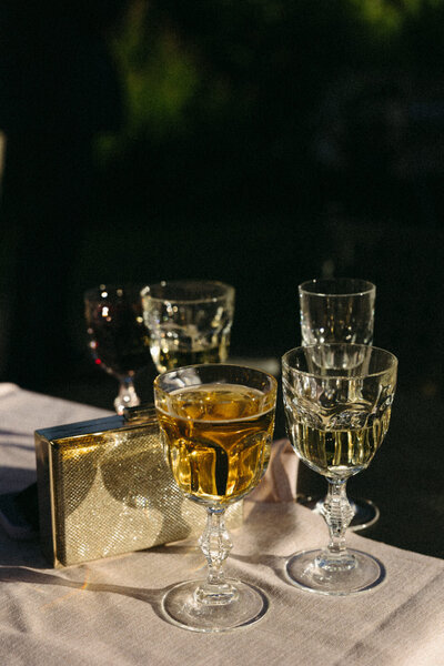 Cocktail drinks and guest's clutch purses at cocktail hour in Tuscany Italy, captured by Andrea-Marie Photography