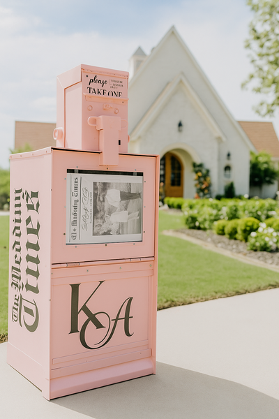 Pink Wedding Times newspaper stand in front of white chapel.