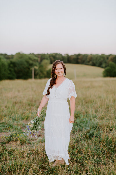 Nashville wedding photographer Christina in a white dress holding a bouquet of wildflowers