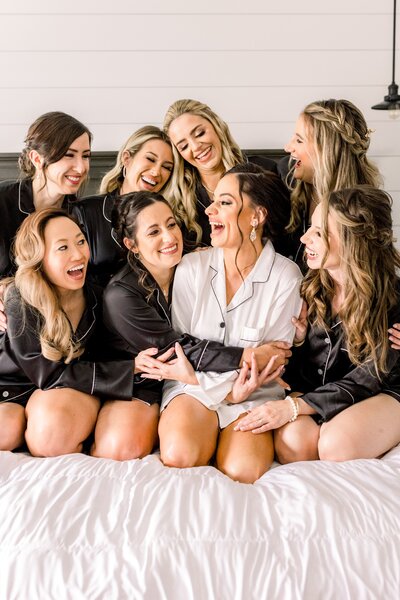 Bride and bridesmaids laugh in matching robes